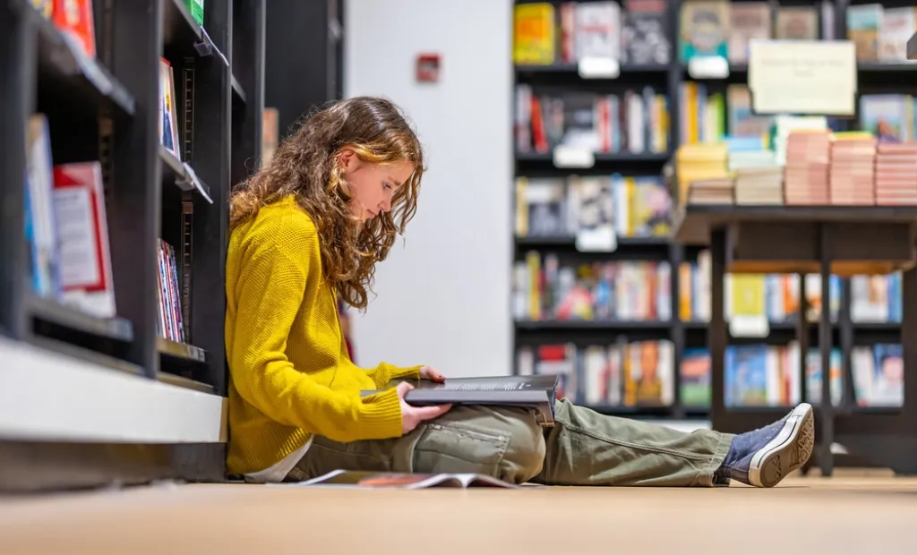 niña leyendo en biblioteca