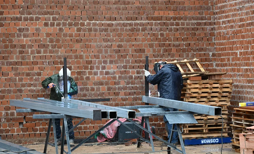 dos personas trabajando en el metal